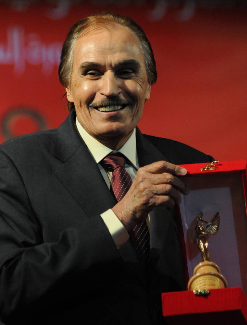 Egyptian actor Ezzat al-Alayli smiles as he holds his lifetime achievement award after being honoured at the 60th Catholic Centre Film Festival in Cairo on May 25, 2012. AFP PHOTO/AMRO MARAGHI (Photo by AMRO MARAGHI / AFP)