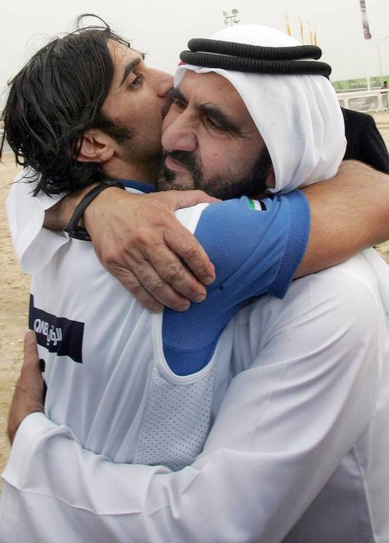 A file picture taken on December 14, 2006 of Vice President and Ruler of Dubai Sheikh Mohammed bin Rashid hugging his son Sheikh Rashid bin Mohammed who finished first in the equestrian endurance competition during the 15th Asian Games in the desert outside Doha. Khaled Nofal / AFP Photo
