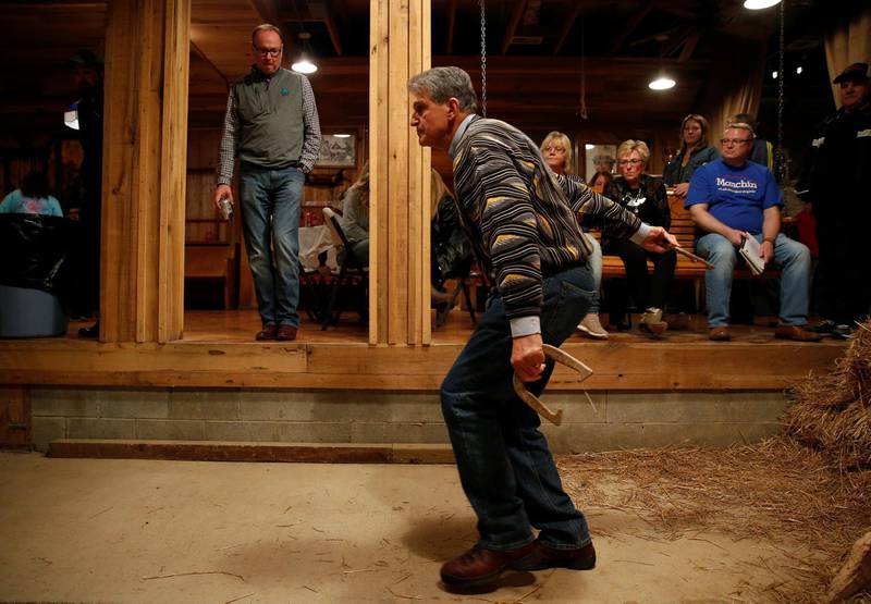 Senator Joe Manchin throws a horse shoe as supporters watc  at Hound Dog Adkins Barn in Peach Creek, West Virginia. Reuters