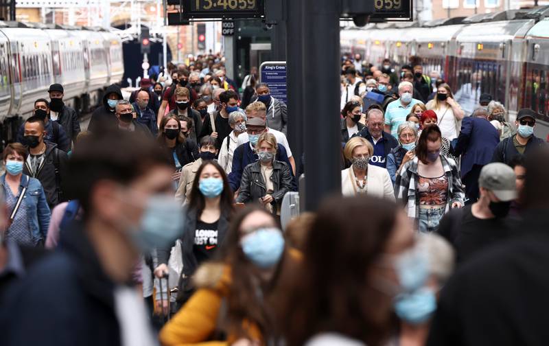 People wearing protective masks walk along a busy platform at King's Cross Station in central London. British Prime Minister Boris Johnson is set to confirm that all remaining coronavirus lockdown restrictions in England will be lifted in a week’s time.