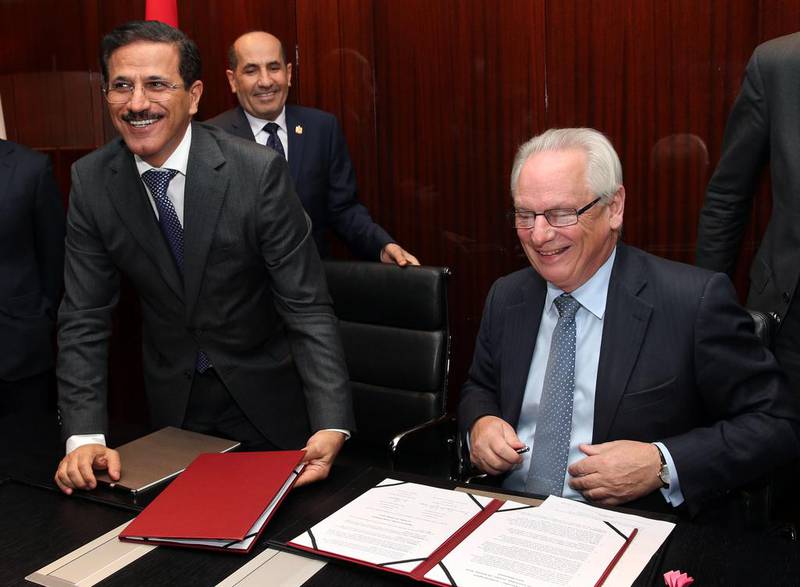 Sultan Al Mansouri, the UAE Minister of Economy, left, with the UK trade and investment minister Francis Maude while UAE ambassador to the Abdulrahman Ghanem Almutaiwee, back, looks on during a signing ceremony. Stephen Lock for the National