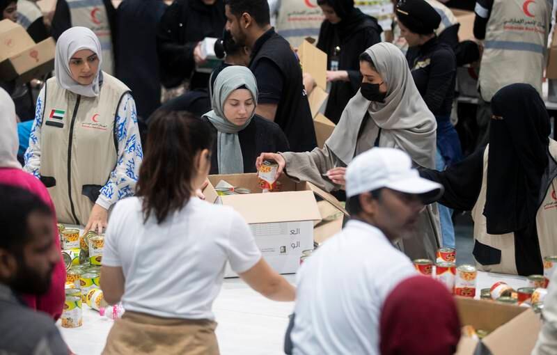 Volunteers pack food, blankets and other essential goods at the Dubai Exhibition Centre, at Expo City
