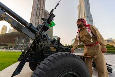 A Dubai Police officer fires a cannon at Burj Park. Officers fire two rounds to announce the beginning and end of Ramadan. Chris Whiteoak / The National