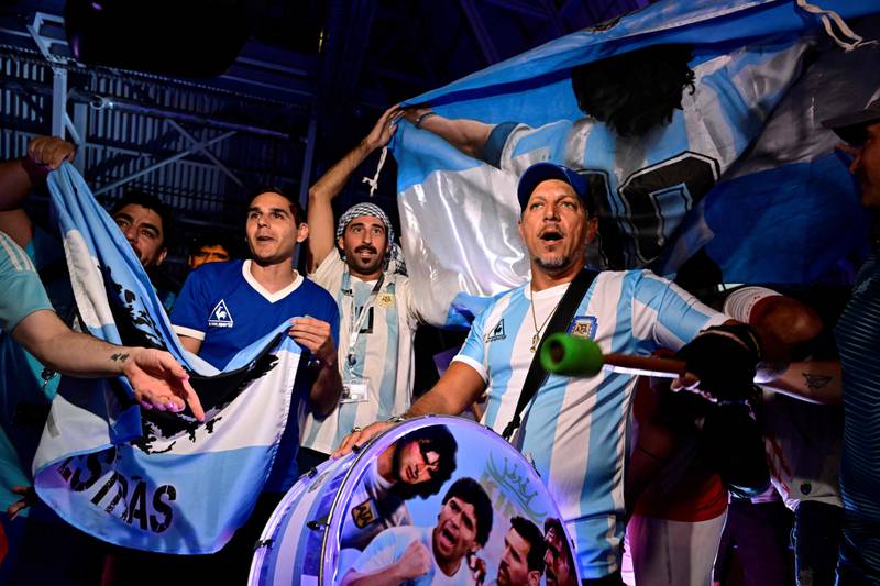 Fans of Argentina's Diego Maradona cheer as the pay tribute on the second anniversary of his death at a fan zone devoted to the Argentine at Doha's international airport. AFP