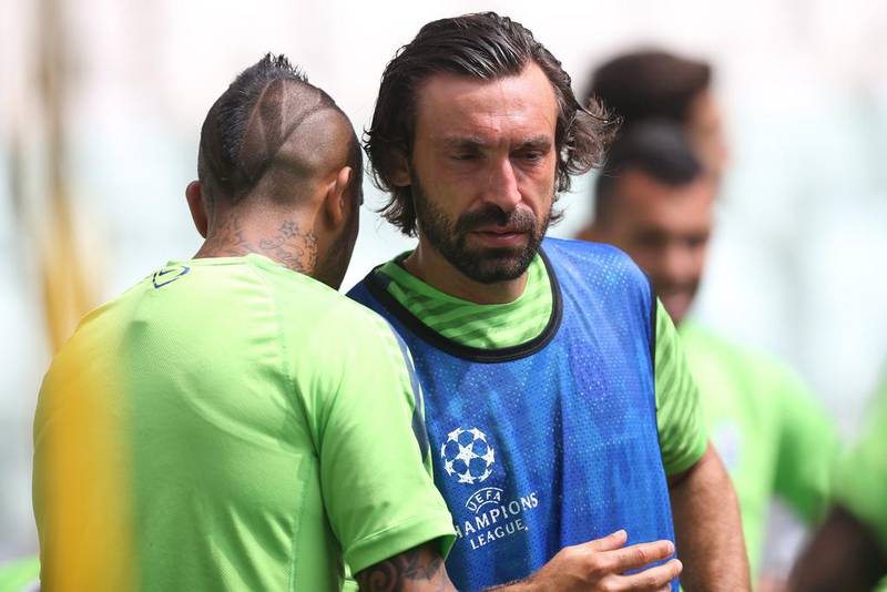 Arturo Vidal of Juventus talks with teammate Andrea Pirlo on Monday at the team's training session ahead of the Champions League final against Barcelona. Marco Bertorello / AFP