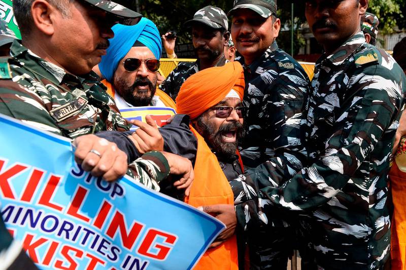 Centre Reserve Police (CRP) detain National Akali Dal President Paramjit Singh (centre) during a protest demanding US President Donald Trump to take action against Pakistan, in New Delhi, ahead of Trump's first official visit to India.  AFP