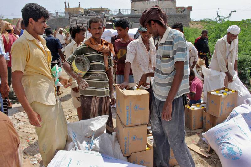 Yemenis displaced from the port city of Hodeidah receive humanitarian aid donated by the World Food Programme (WFP) in the northern province of Hajjah on September 25, 2018. The three-year conflict between Yemen's Saudi-backed government and Huthi rebels linked to Iran has pushed the already impoverished country to the brink of famine, leaving many unable to afford food and water. / AFP / ESSA AHMED
