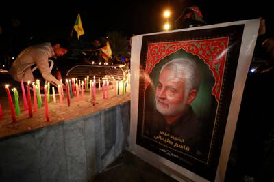 A man holds a large poster of Suleimani as Iraqis light candles near Baghdad's International Airport. AFP