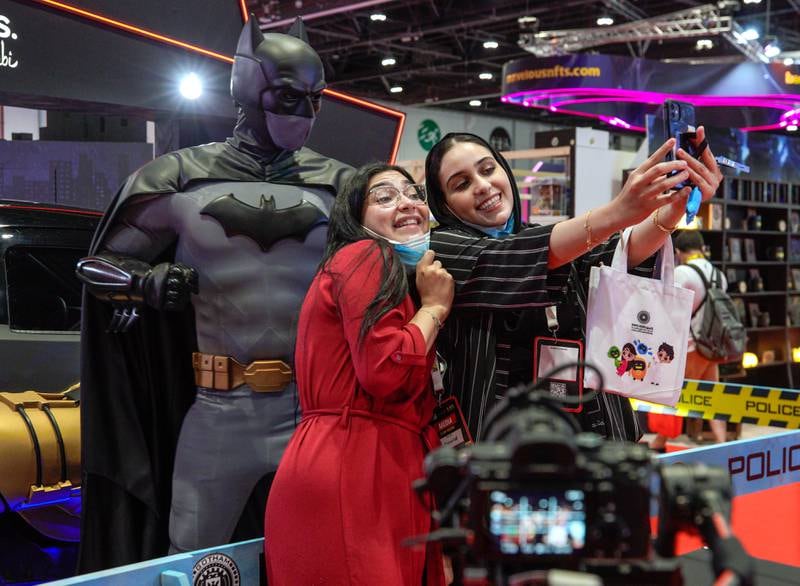 Women take a selfie with the Batman statue.