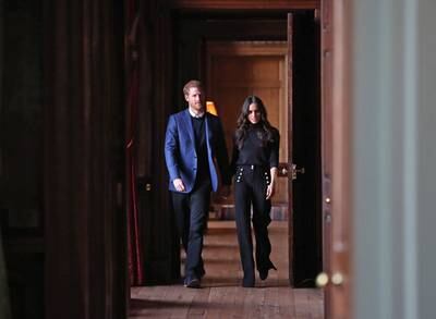 Prince Harry and Meghan walk through the corridors of the Palace of Holyroodhouse on their way to a reception for young people at the Palace in February 2018 in Edinburgh, Scotland. Getty
