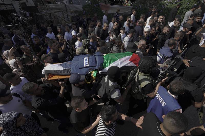 Palestinian militants carry the body into the hospital morgue in Jenin. AP