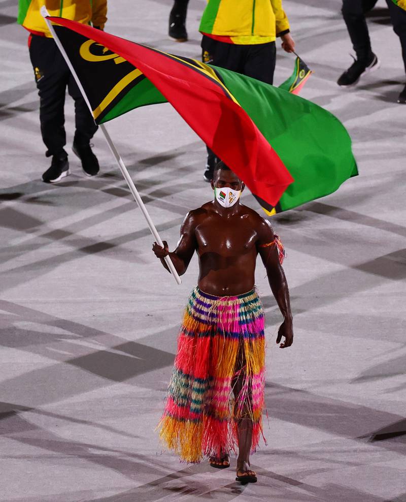 Flag bearer Rillio Rii of Vanuatu leads his contingent during the athletes parade at the opening ceremony.