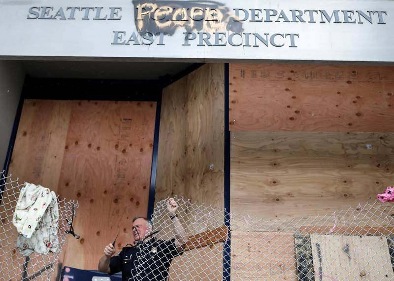 A police officer removes a wire barricade at the entrance of Seattle Police Department East Precinct in Seattle. Reuters
