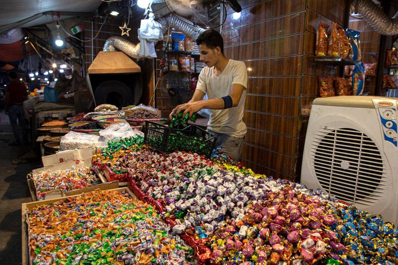 A sweets seller adjusts his products ahead of Eid Al Fitr, in downtown Amman, Jordan.  EPA