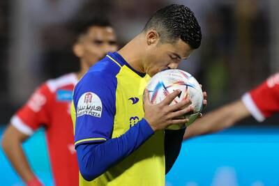Al Nassr forward Cristiano Ronaldo kisses the ball before taking a penalty. The Portuguese striker converted for his hat-trick - the 61st treble of his career. AFP