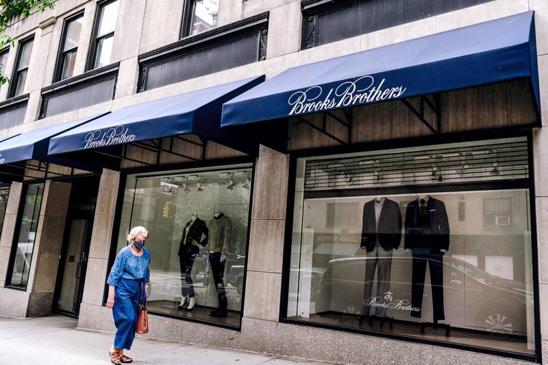 A pedestrian wearing a protective mask passes in front of a Brooks Brothers store on Madison Avenue in New York, U.S., on Saturday, Sept. 26, 2020. The pandemic has battered New York City businesses, with almost 6,000 closures, a jump of about 40% in bankruptcy filings across the region and shuttered storefronts in the business districts of all five boroughs. Photographer: Nina Westervelt/Bloomberg