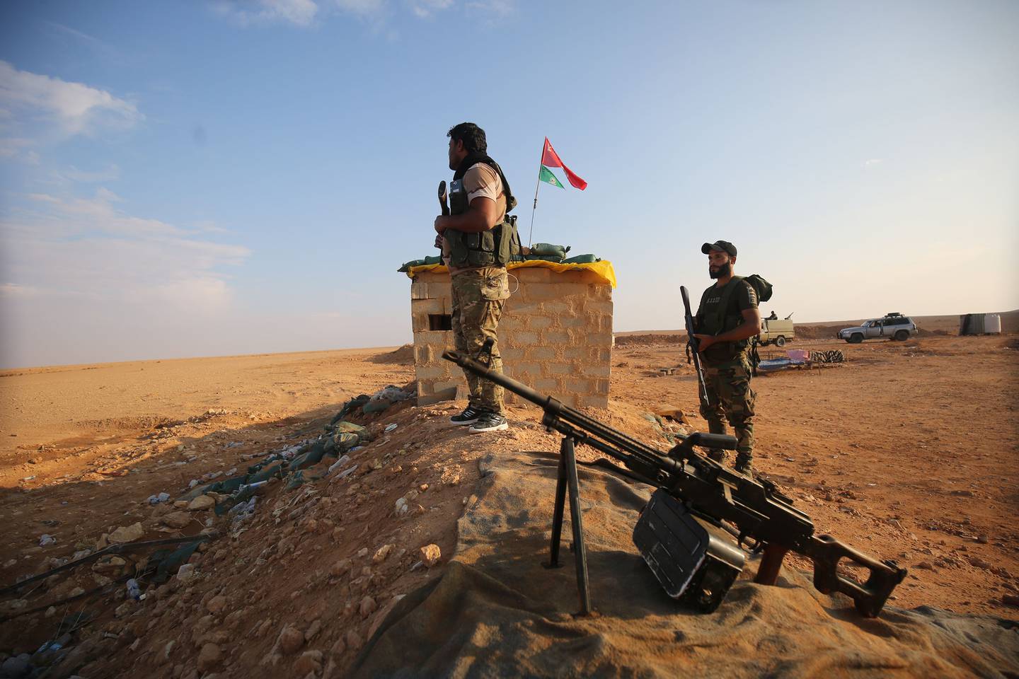 Des combattants chiites irakiens de la force paramilitaire Hashed al-Shaabi sécurisent la frontière à al-Qaim dans la province d'Anbar, en face d'Albu Kamal dans la région syrienne de Deir Ezzor, le 12 novembre 2018. Les troupes irakiennes ont renforcé leurs positions le long de la frontière poreuse avec la guerre voisine -la Syrie déchirée, craignant un débordement des affrontements entre les djihadistes du groupe État islamique et les forces soutenues par les États-Unis.  La force auxiliaire Hashed al-Shaabi (mobilisation populaire) a été créée par le gouvernement irakien en 2014, après un appel au djihad du chef spirituel de la communauté chiite, le grand ayatollah Ali Sistani, pour aider à la lutte contre l'EI en Irak.  / AFP / AHMAD AL-RUBAYE