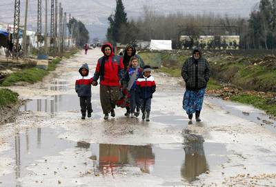 Syrian refugees walk along a makeshift settlement in Bar Elias in the Bekaa valley on January 5, 2015. Mohamed Azakir/Reuters 
