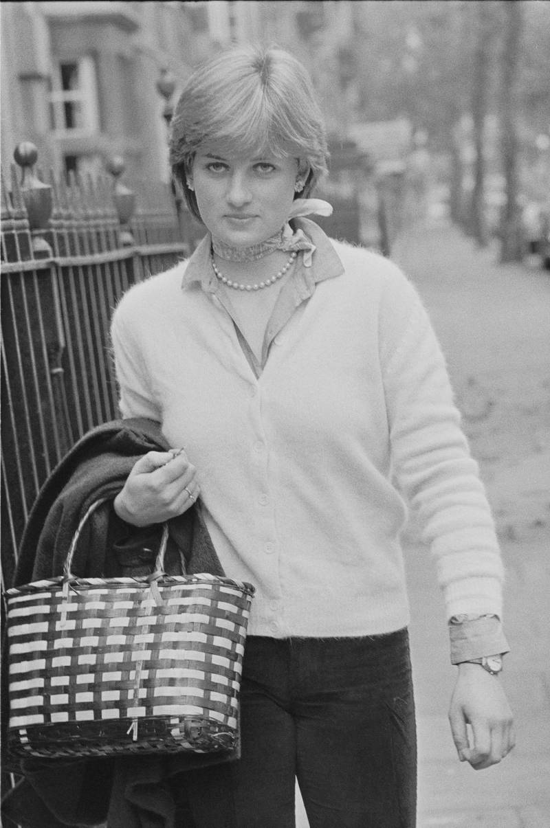 Lady Diana Spencer (1961 - 1997) walking on a sidewalk holding her coat and handbag, she is wearing pale cardigan, shirt, neck-scarf and pearl necklace, London, UK, 13th November 1980. (Photo by Stuart Clarke/Evening Standard/Hulton Archive/Getty Images)