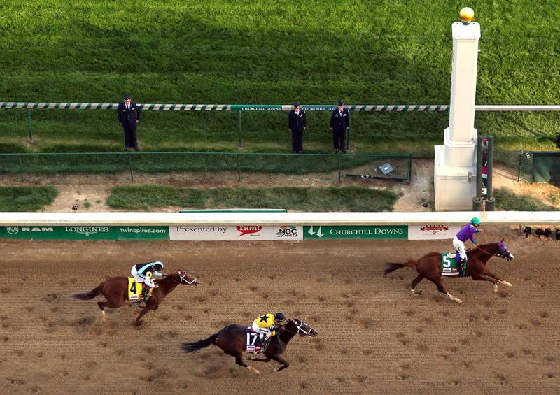 California Chrome with Victor Espinoza up crosses the finish line ahead of Commanding Curve, No 17, and Danza, No 4, to win the 140th running of the Kentucky Derby at Churchill Downs. Jamie Squire / Getty Images / AFP