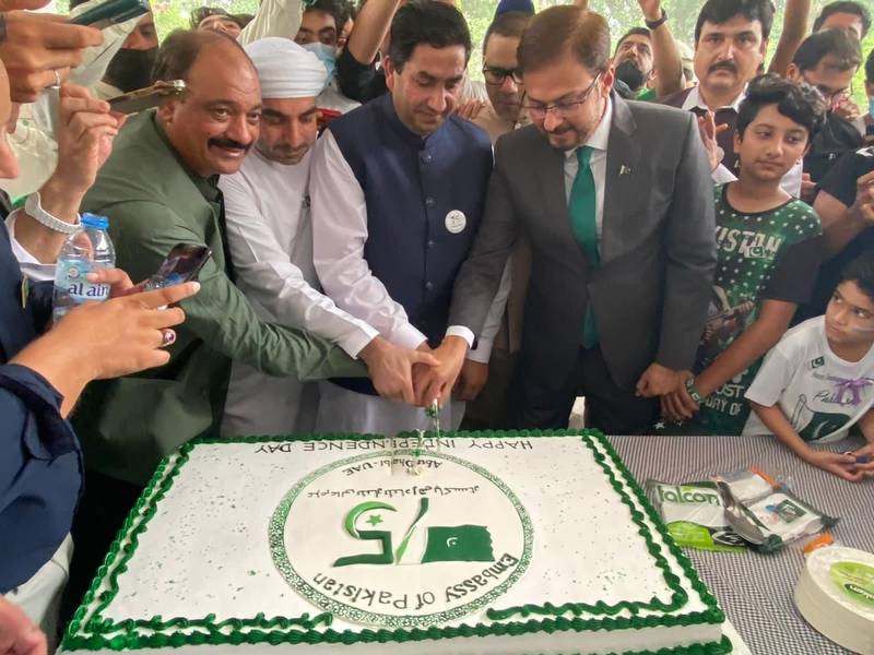 Pakistan officials and residents cutting a large cake to celebrate the day. 