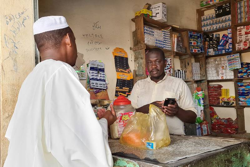A grocer serves a customer at a shop in Khartoum on May 30. AFP