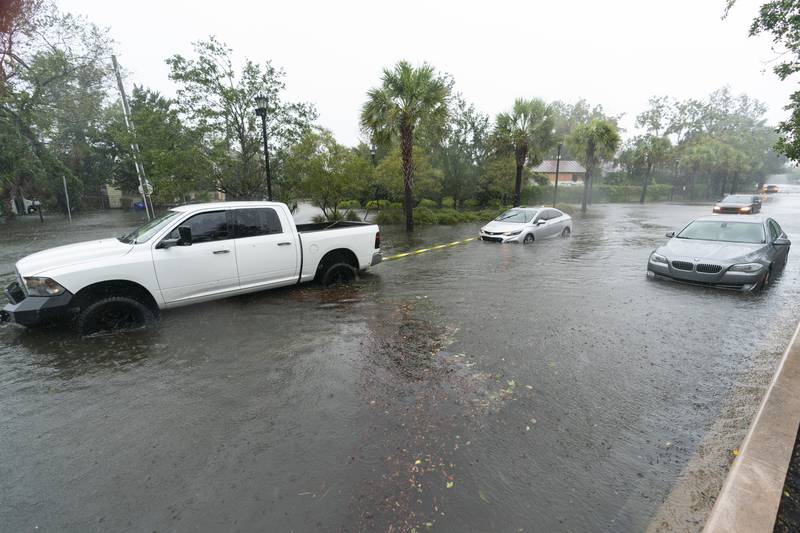 A good Samaritan pulls a stuck motorists from the high waters as Hurricane Ian batters Charleston. AP