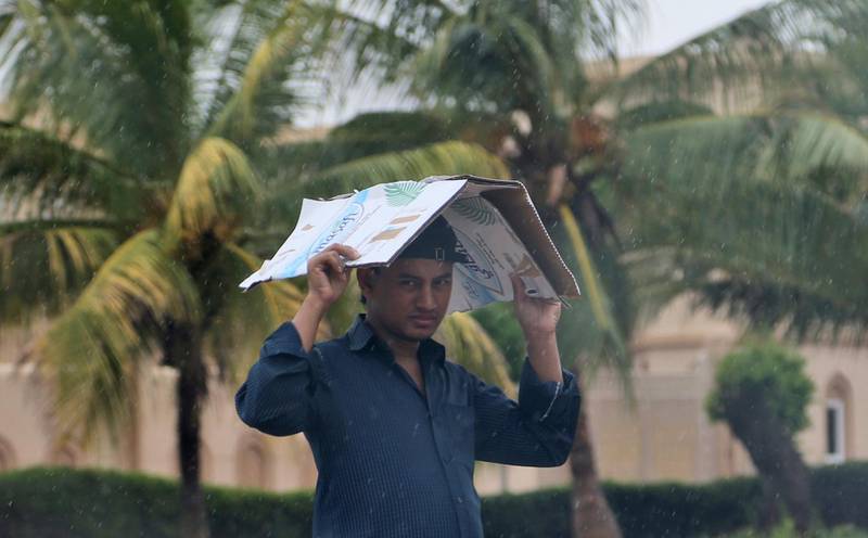 A man covers his head under the rain. Kamran Jebreili / AP Photo
