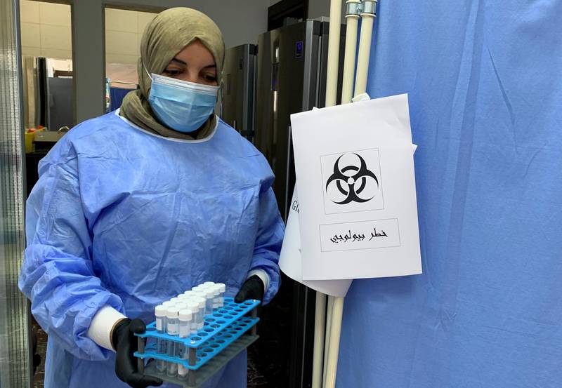 A doctor carries samples before analysing them to ensure they are not infected with Covid-19 at a medical center in Misrata, Libya. Reuters