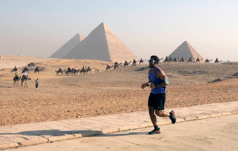 Participants run during the fourth edition of the Pyramids Half Marathon at the Giza Plateau in Giza, on the outskirts of Cairo, Egypt, 10 December 2022.  Runners from around the world participated in the Pyramids Half Marathon running event, offering distances of 21km, 10km and 5km, at the Giza Plateau, home of the Great Pyramids of Giza.   EPA / KHALED ELFIQI
