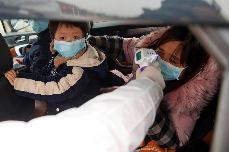 A medical worker in protective suit checks the body temperature of car passenger at a checkpoint outside the city of Yueyang, Hunan Province, near the border to Hubei Province that is on lockdown after an outbreak of a new coronavirus, China. Reuters
