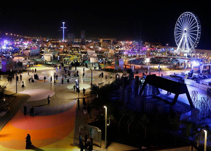 In this Dec. 13, 2019 photo, people spend the evening at the Diriyah Oasis amusement park in Diriyah on the outskirts of Riyadh, Saudi Arabia. Hollywood actors, models and social media mavens were invited to Saudi Arabia over the weekend to promote a three-day-long musical festival for young Saudis that took place in the capital, Riyadh. The efforts are aimed at boosting the economy while polishing the country's image abroad and appealing to the young. It's a pivot from just three years ago, when religious police would storm restaurants playing music and harass women in malls for showing their face or wearing red nail polish. (AP Photo/Amr Nabil)