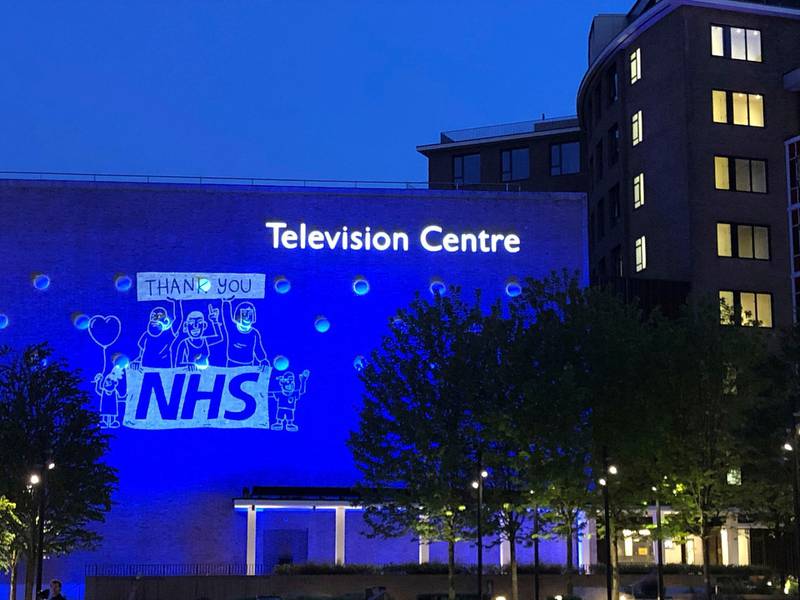 BBC Television Centre in London is lit up in tribute to the National Health Service workers and carers fighting the coronavirus pandemic. PA via AP