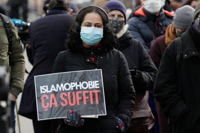 A woman holds a placard reading "enough of islamophobia" as protesters demonstrate against a bill dubbed as "anti-separatism", in Paris on February 14, 2021. French lawmakers a few weeks ago began debating a controversial bill against what the interior minister described as the "disease" of Islamist extremism eating away at the country's unity. President Emmanuel Macron has pushed for the legislation, which would tighten rules on issues ranging from religious-based education to polygamy, since a spate of attacks blamed on extremists late last year. / AFP / GEOFFROY VAN DER HASSELT
