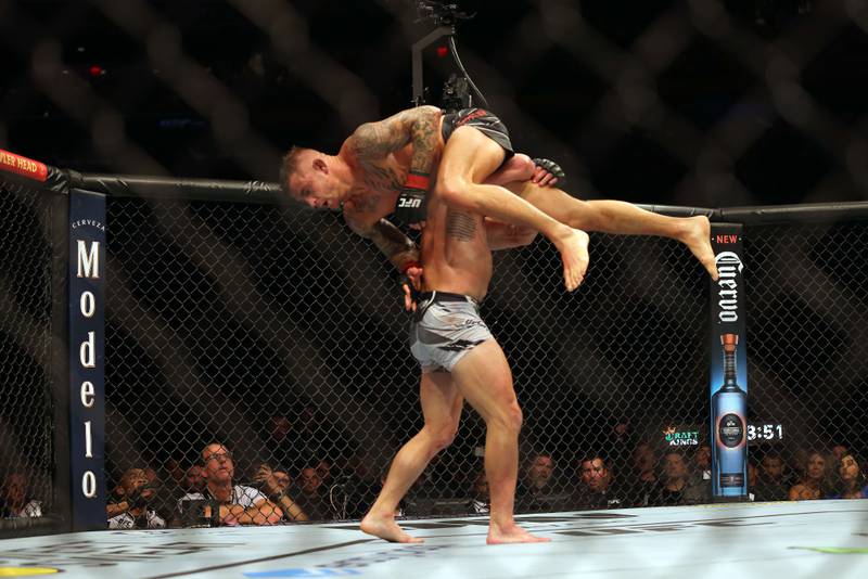 Michael Chandler lifts Dustin Poirier during their lightweight fight at UFC 281. Getty