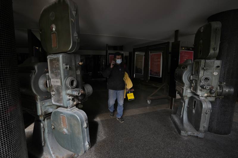 A man passes next to old movie projectors placed outside a theatre in Hamra Street. The projectors were used in the past at the movie theatre once known as Saroula.