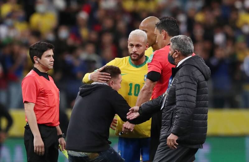 A pitch invader is seen holding Brazil's Neymar after the match. Reuters