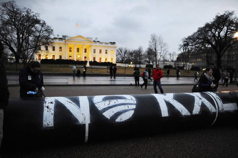 (FILES) In this file photo taken on February 03, 2014, environmental activists inflate a long balloon to mock the Keystone pipeline project during a demonstration in front of the White House in Washington, DC. Canada’s TC Energy and the provincial government of Alberta announced on June 9, 2021, they have terminated the Keystone XL Pipeline Project , bringing an end to a decade-long controversy over an effort to pipe more Canadian crude into the US / AFP / JEWEL SAMAD
