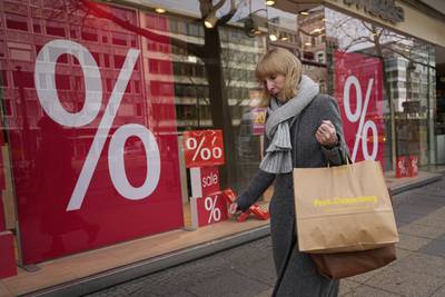 A woman walks with purchases past a store in Berlin.  In December, consumer price growth across the Euro zone slowed to 9.2 per cent from 10.1 per cent a month earlier, Eurostat data showed last week. AP 