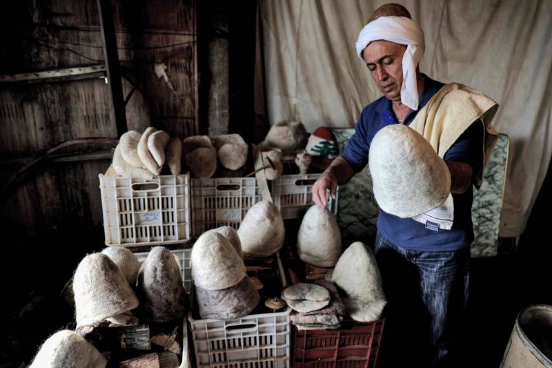 Hatmaker Youssef Akiki inspects some of his traditional 'Labbadeh' hats at his workshop in the mountain town of Hrajel in Lebanon. AFP