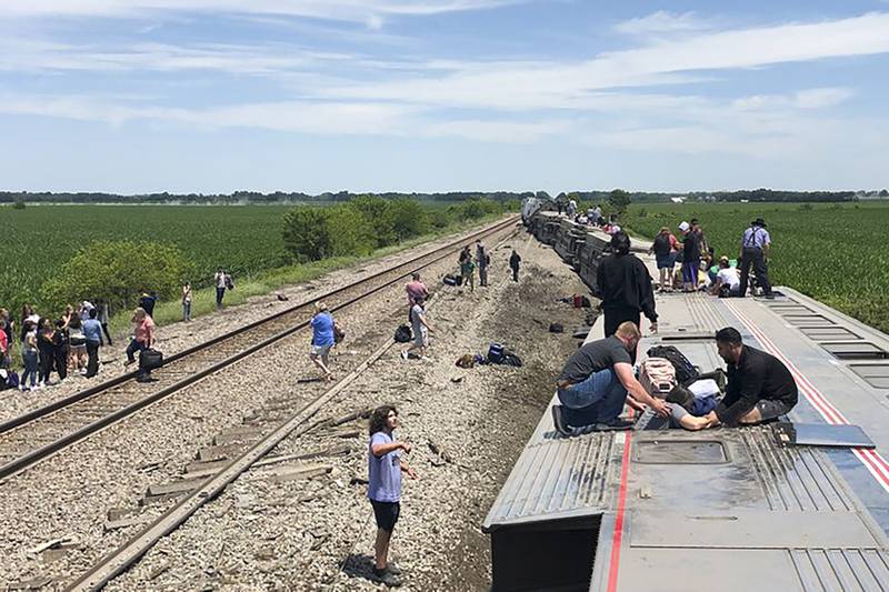 In this photo provided by Dax McDonald, an Amtrak passenger train lies on its side after derailing near Mendon, Missouri, June 27, 2022. AP