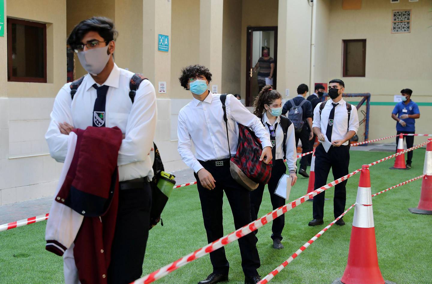 SHARJAH, UNITED ARAB EMIRATES , September 28 – 2020 :- Students standing in a queue to enter in their classroom on the first day of the school after reopening at the Victoria English School in Sharjah. New Covid safety setup placed in different areas of the school such as hand sanitizer, safety message, social distancing stickers pasted on the floor, disinfection tunnels installed at all the gates of the school. (Pawan Singh / The National) For News. Story by Salam
