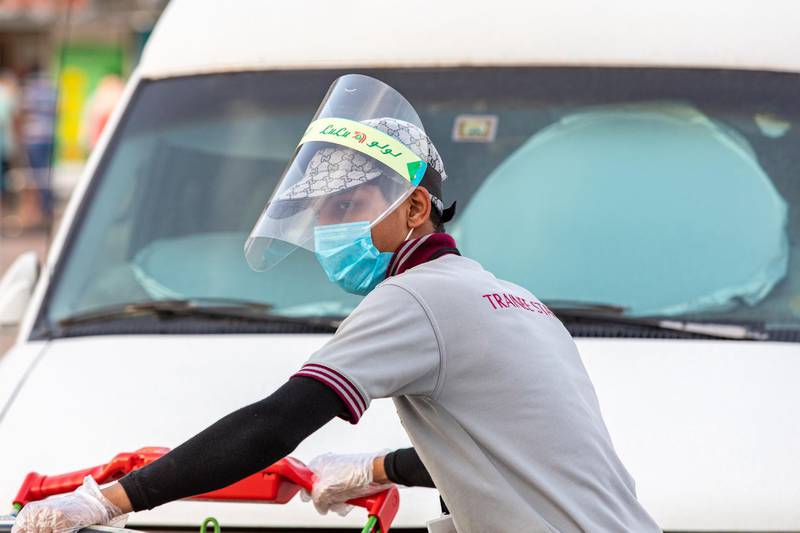An employee wears a protective face mask and shield while collecting carts outside a Lulu hypermarket, operated by Lulu Group International, during the coronavirus lockdown in Dubai, United Arab Emirates, on Thursday, April 23, 2020. An investment firm backed by a member of Abu Dhabi’s royal family agreed to buy a stake worth just over $1 billion in LuLu Group International, which runs one of the Middle East’s largest hypermarket chains, according to people familiar with the matter. Photographer: Christopher Pike/Bloomberg