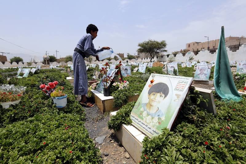 epa06131959 A Yemeni boy sprinkles water near the grave with a portrait of a late child allegedly killed in the ongoing conflict, at a cemetery in Sana’a, Yemen, 08 August 2017. According to UNICEF recent reports, a total of 201 Yemeni children, including 152 boys and 49 girls, have been killed in the ongoing conflict in war-affected Arab country since the beginning of 2017.  EPA/YAHYA ARHAB