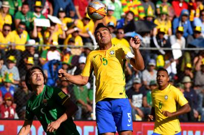 Brazil midfielder Casemiro heads the ball ahead of Bolivia's Marcelo Martins. Nelson Almeida / AFP