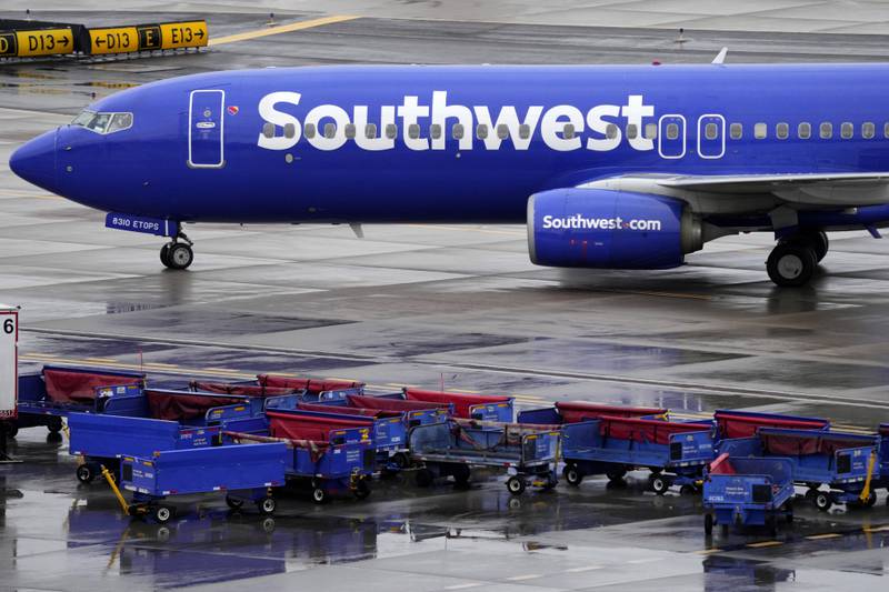 A Southwest jet passes unused luggage carts at Sky Harbour International Airport in Phoenix, Arizona. AP