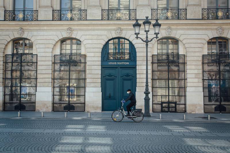 A cyclist wearing a protective face mask passes the Louis Vuitton luxury goods store, operated by LVHM Moet Hennessy Louis Vuitton SE, on Place Vendome in Paris, France, on Wednesday, May 6, 2020. In his ninth-floor office on Paris’s Avenue Montaigne, Europe’s wealthiest man, Bernard Arnault, is spending long hours plotting a post-virus future for his luxury goods empire, LVMH. Photographer: Cyril Marcilhacy/Bloomberg