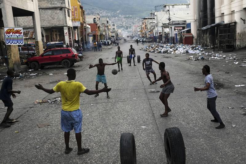 Youths play soccer next to businesses that are closed due to a general strike in Port-au-Prince. AP