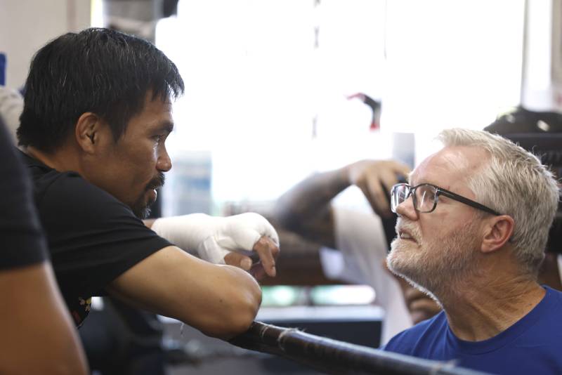 Manny Pacquiao talks with his coach Freddie Roach.