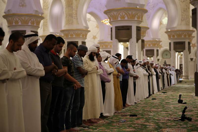 Men stand for prayer after breaking their fasts in Sheikh Zayed Mosque on the first day of Ramadan in 2016. Ravindranath K / The National